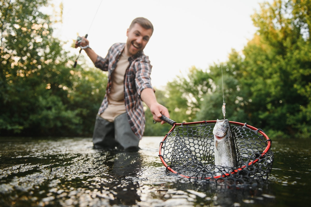 Smiling man after he caught a fish in his net